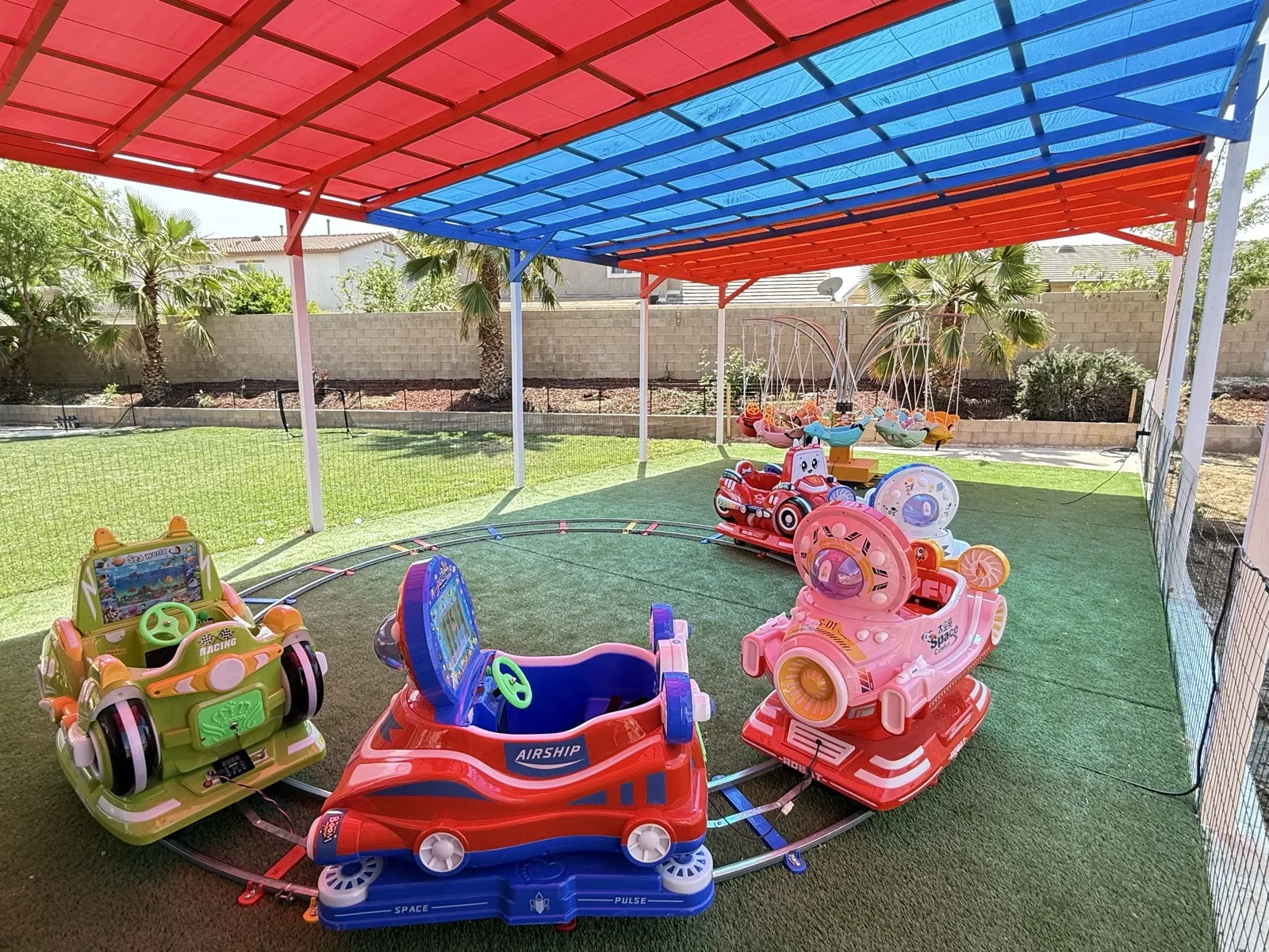 Toddlers Enjoying Ride-On Cars Under Colorful Canopy at Fairy Tale Child Care Palmdale
