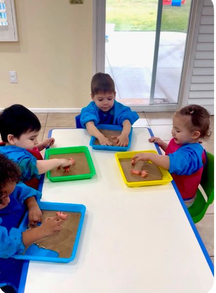 Children playing with sensory sand bins at Fairy Tale Child Care